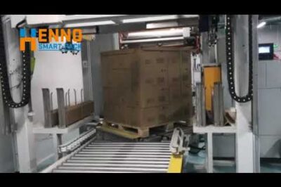 Vertical strapping machine with paper corner applicator for pallets.