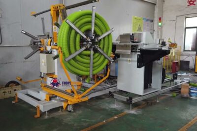 Coiling and strapping machine for double wall hoses.