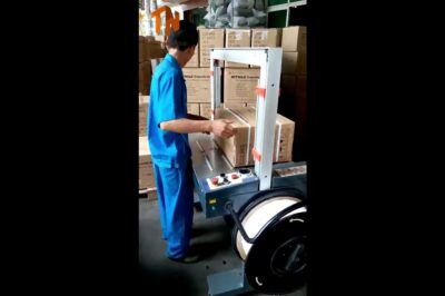 Fully automated machine for strapping cartons