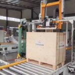 Pallet strapping machine with conveyor line for efficient double turn strapping in under 28 words.