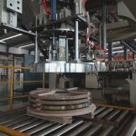Automated coil handling and stacking system for steel strips.
