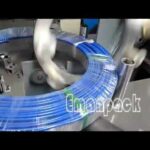 coil wrapping machine packages large hose and pipe rolls horizontally.