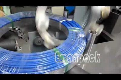 Coil wrapping machine packages large hose and pipe rolls horizontally.