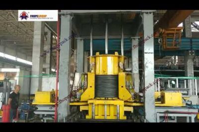 Machine for compressing and strapping steel wire rod coils automatically.