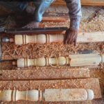 making wooden stair railing parts with a lathe machine.