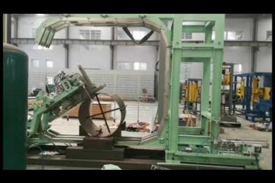 Online steel coil strapping machine for secure packaging and shipping.